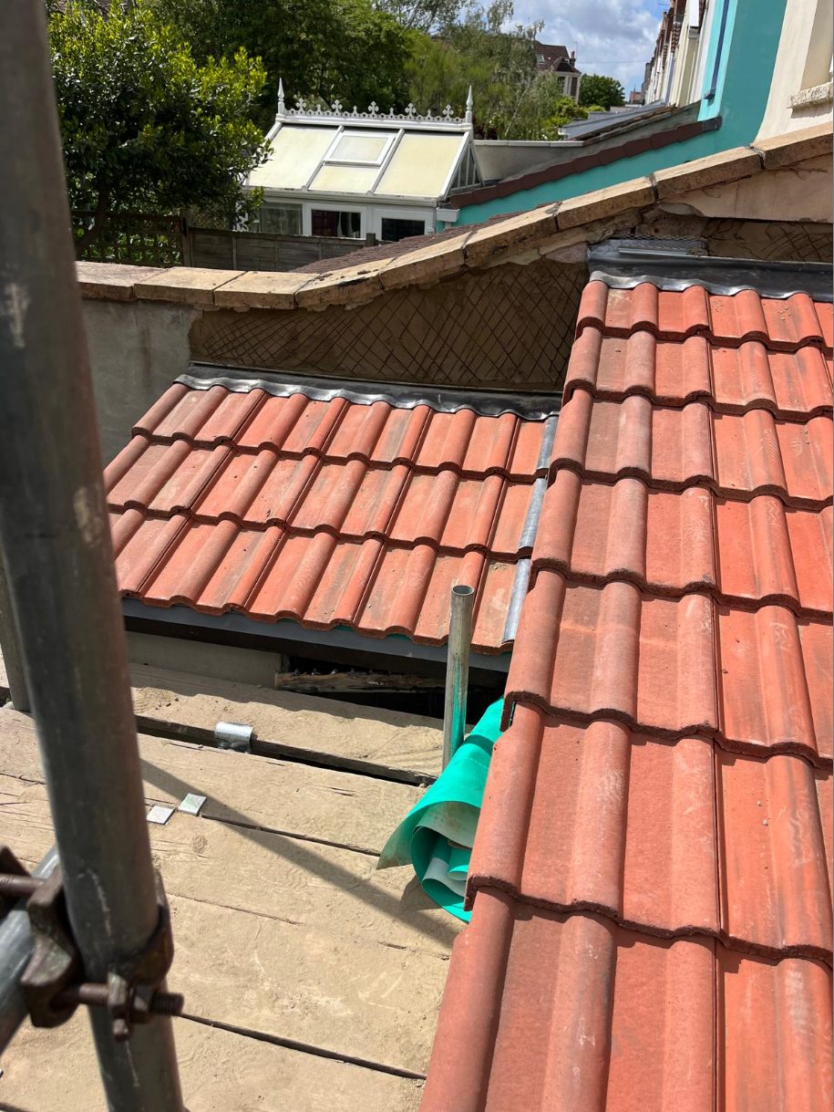 New tiles and lead where two roof pitches meet — clean, watertight.